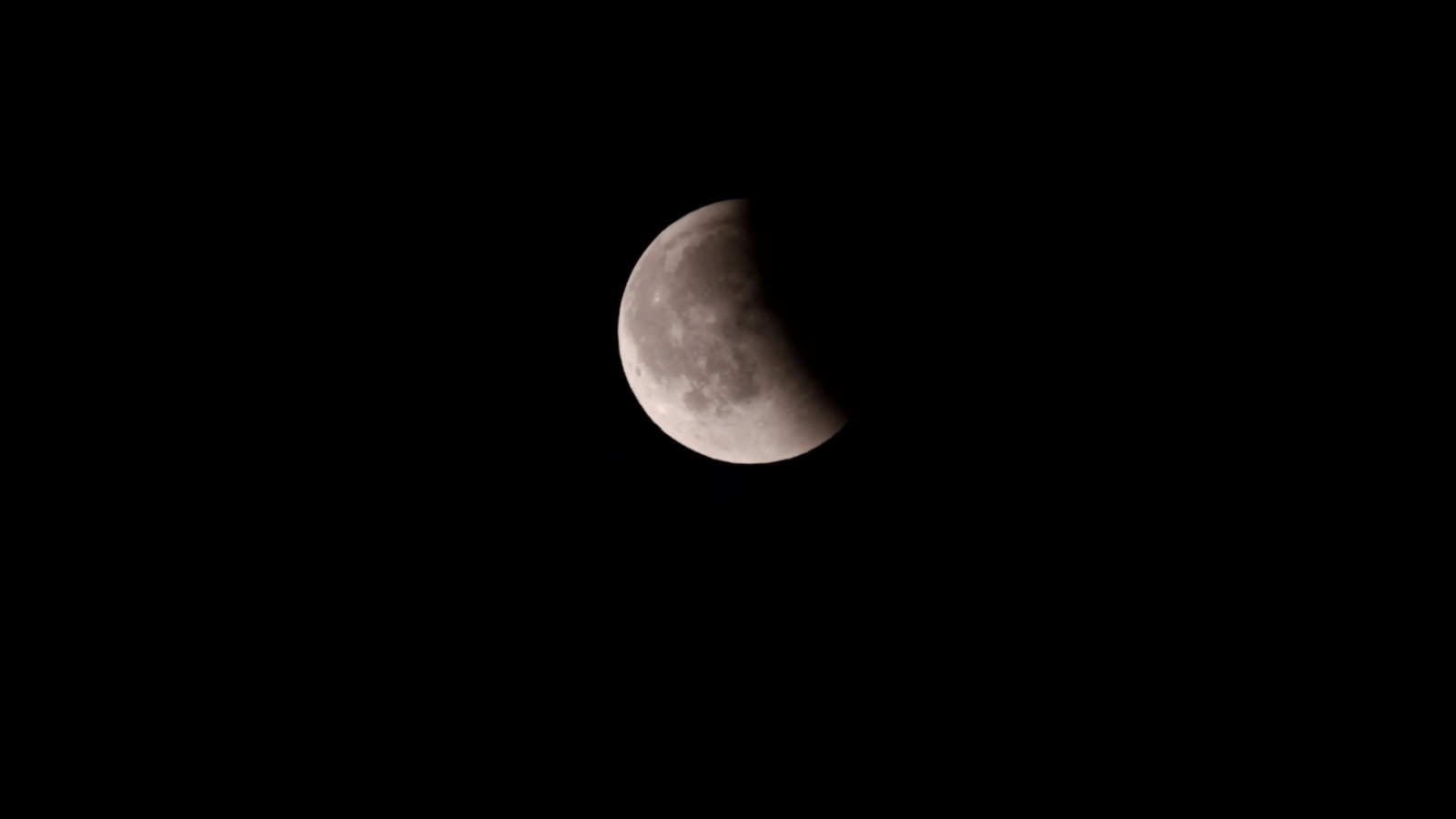 Teilweise von Schatten bedeckter Mond am Nachthimmel.