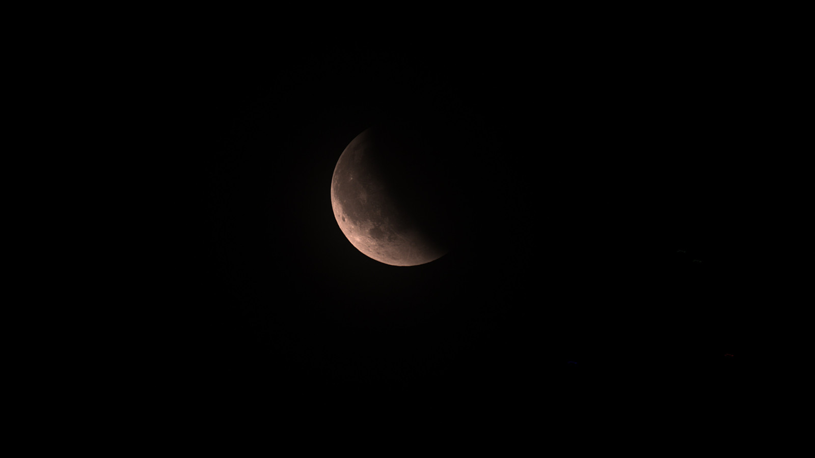 Teilweise beleuchteter Mond vor schwarzem Hintergrund.